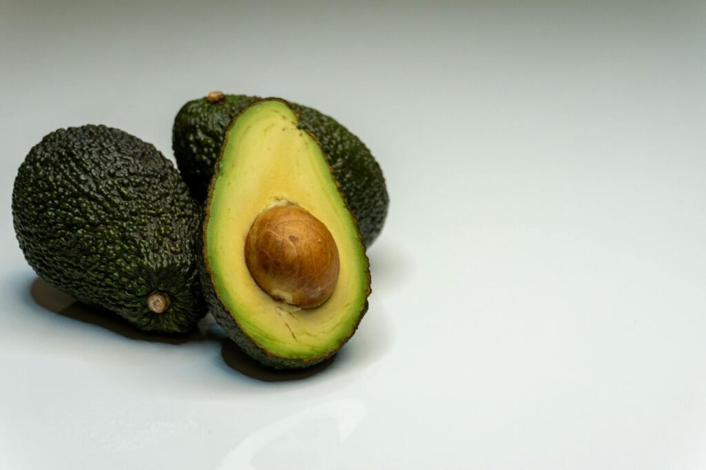 A cut avocado stored in an airtight container in a refrigerator