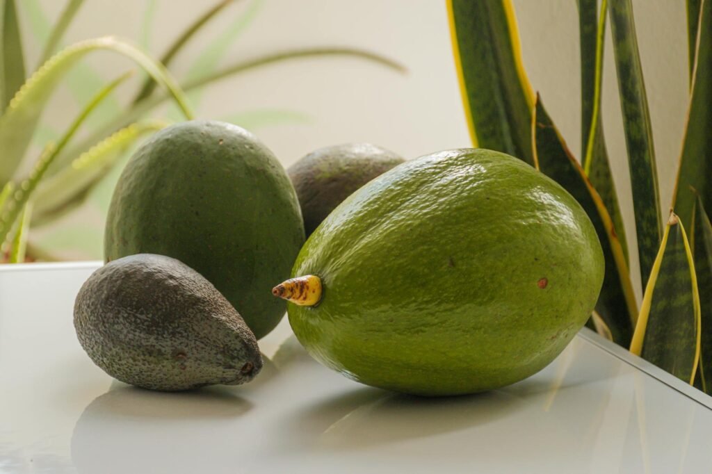 Two avocado halves side by side, one lightly browned and one visibly spoiled