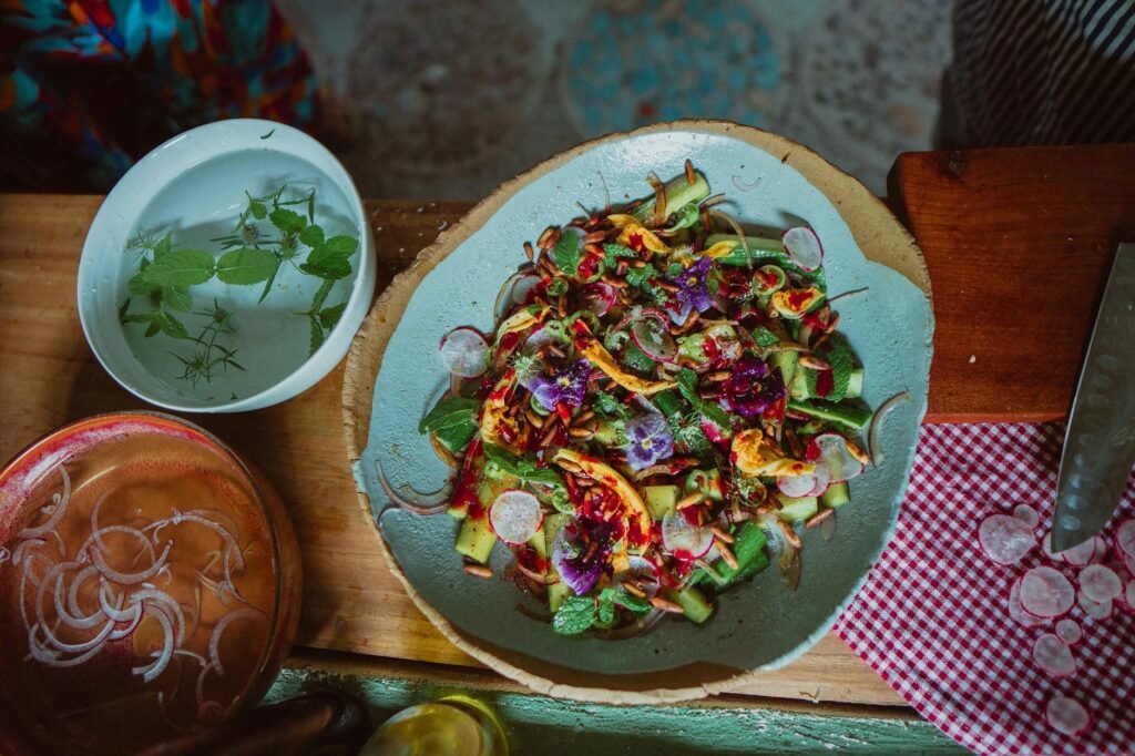 A finished avocado salad with avocado, cucumber, beans, seeds, and herbs in natural light