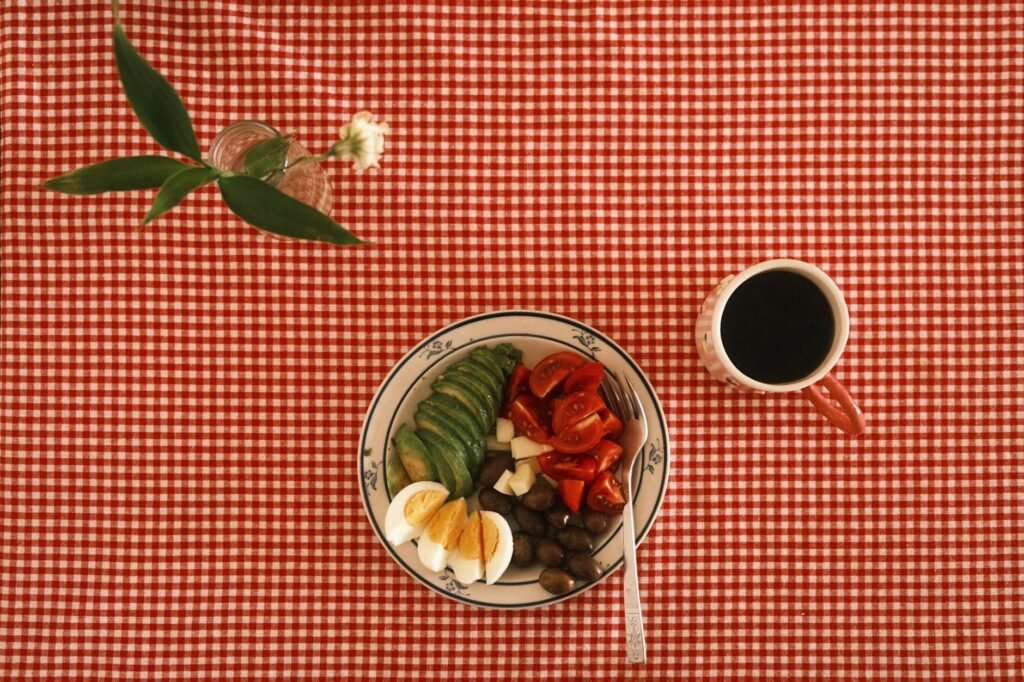 A breakfast bowl with crispy potatoes, avocado slices, and salsa in a simple ceramic bowl.