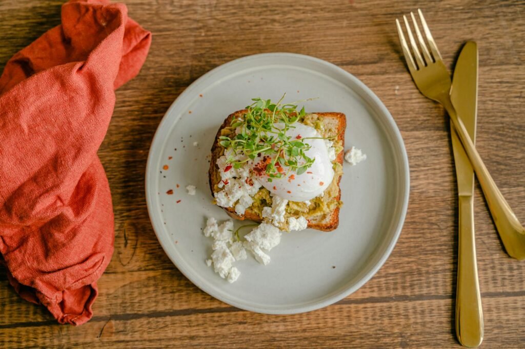 A breakfast plate with avocado, cottage cheese, egg, and toast