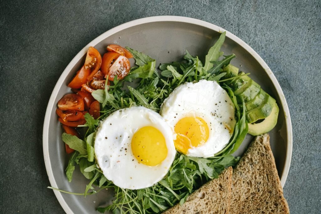 A balanced lunch plate with half an avocado, vegetables, and protein