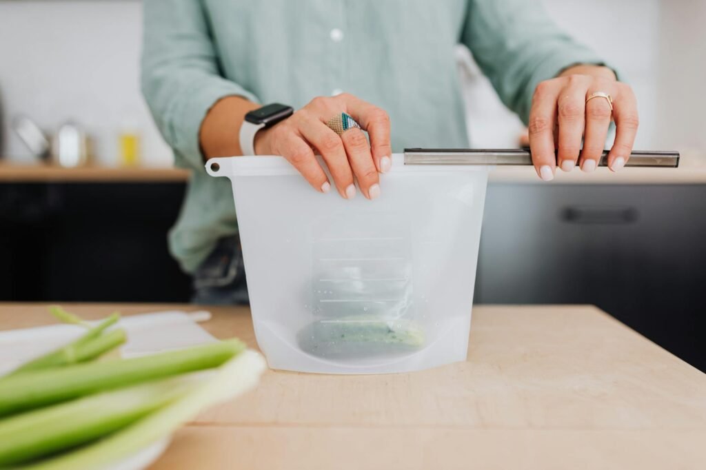 A cut avocado half with lemon and an airtight container ready for refrigerator storage