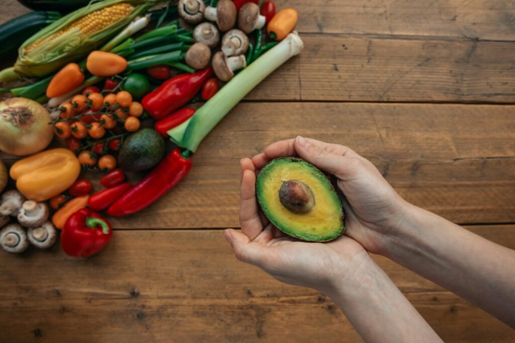 A hand checking avocado firmness with the whole palm instead of fingertips.