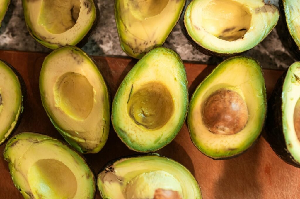A cut avocado half wrapped tightly and stored in a small refrigerator container