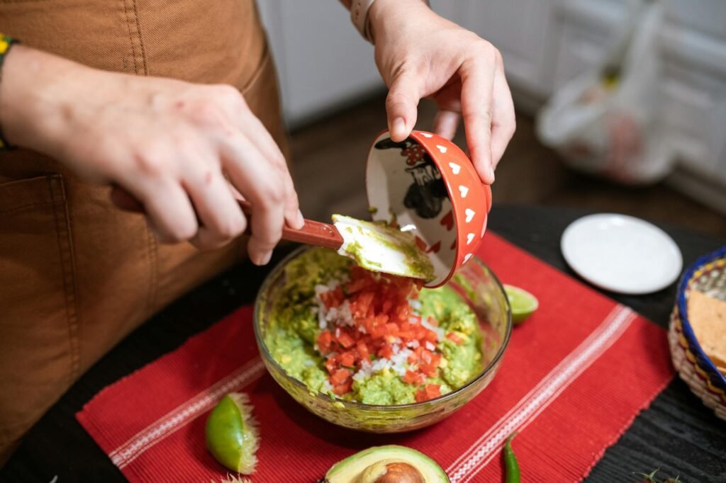 Close-up of chunky guacamole in a bowl with visible avocado texture.