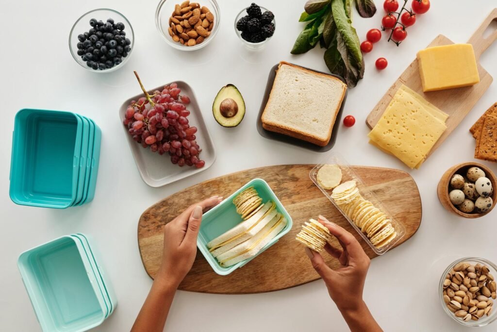 Meal-prep containers with avocado, beans, and greens on a kitchen counter