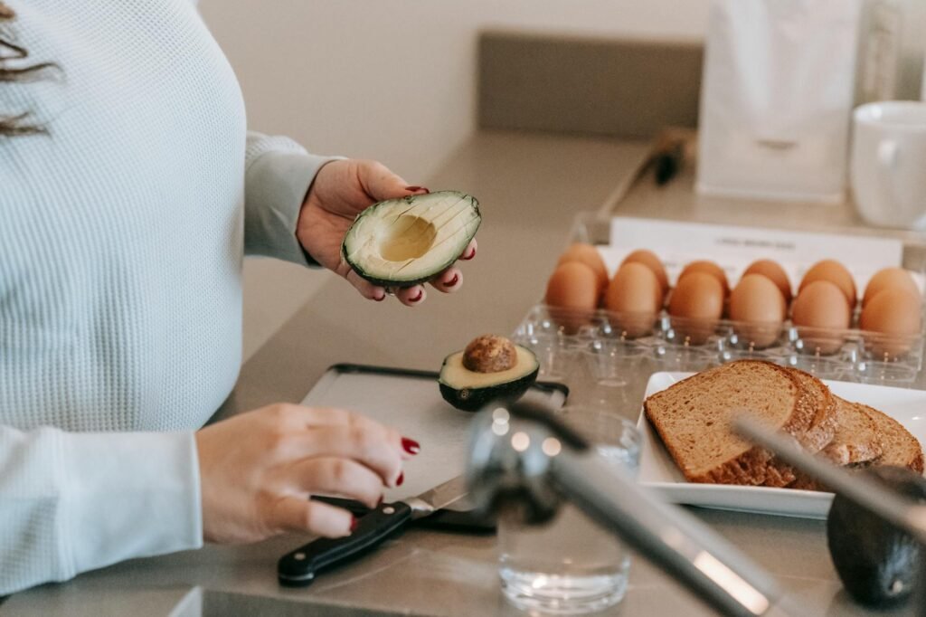 Kitchen prep scene with toasted bread, avocado, lemon, salt, and a small bowl
