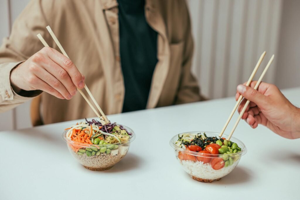 Meal-prep grain bowl with avocado, black beans, tomatoes, cabbage, and rice