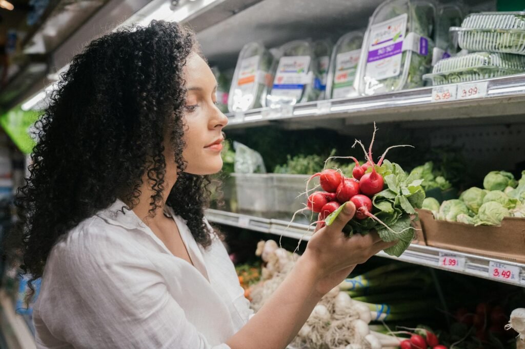 A shopper gently checking an avocado in the palm of their hand in the produce aisle.