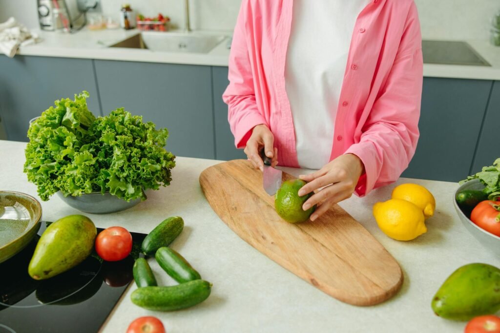 A ripe avocado on a cutting board in a clean kitchen prep area.