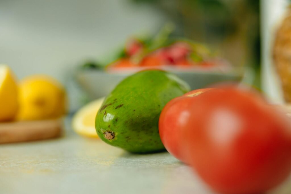 Avocados at different ripeness stages stored between a countertop and refrigerator.