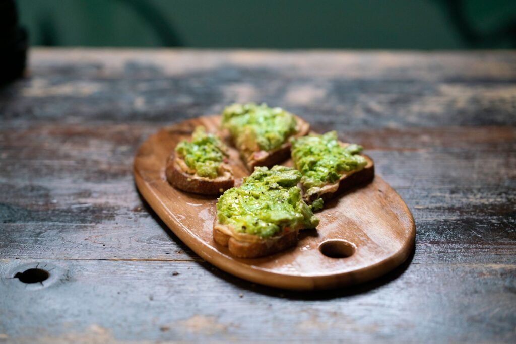 Whole-grain toast topped with mashed avocado on a clean kitchen counter