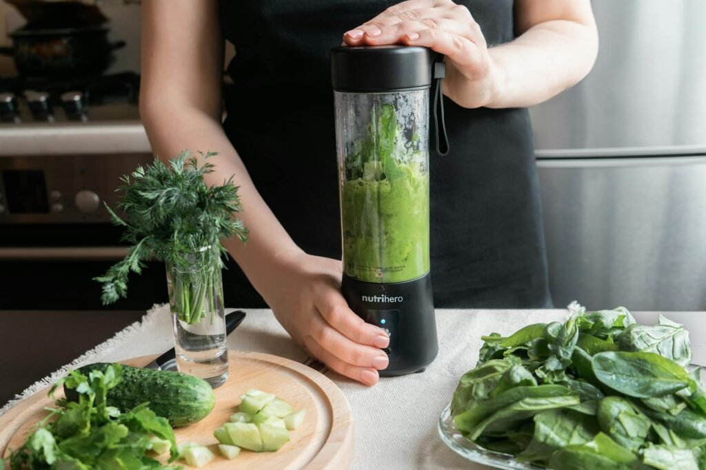 A blender with smoothie ingredients and a small frozen avocado portion ready to be added