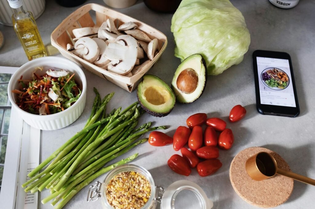 Grocery bag with avocados, oats, beans, greens, and olive oil on a kitchen table