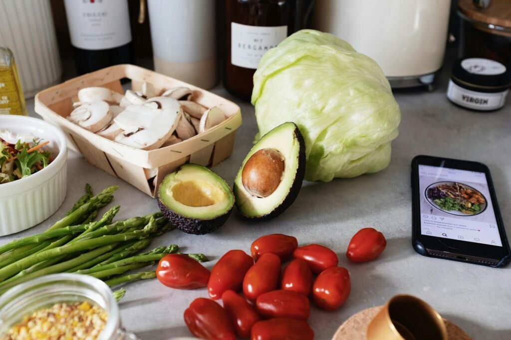 Several avocados arranged from firm green to ripe dark skin on a kitchen counter.