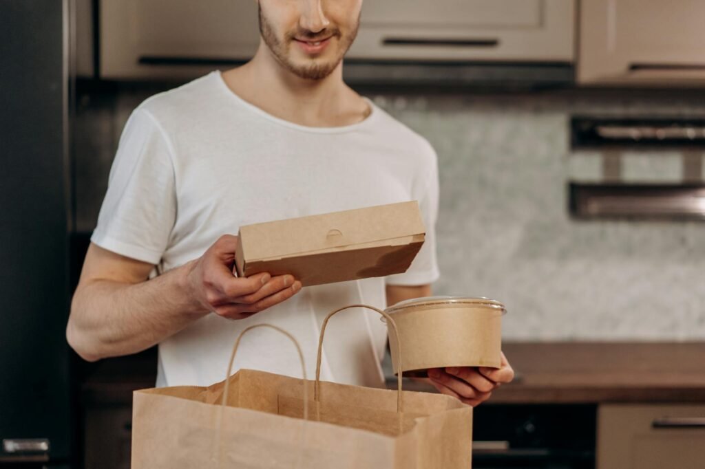 Avocados at different ripeness stages beside a paper bag and labeled containers