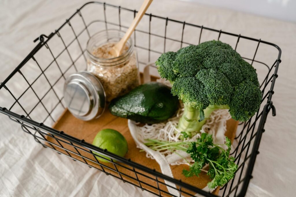 Mashed avocado in a glass container with plastic wrap pressed directly onto the surface.