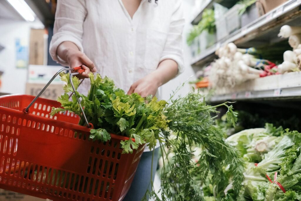 A shopper gently holding an avocado in the produce section