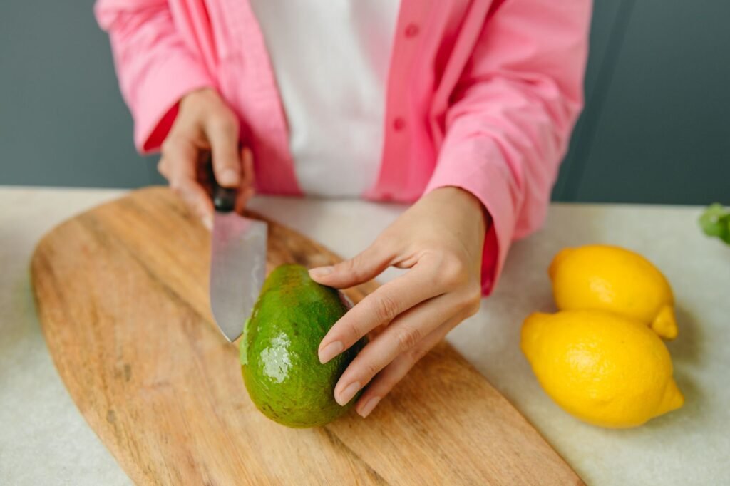 Ripe avocados, a lemon, and labeled freezer bags arranged on a kitchen counter for meal prep